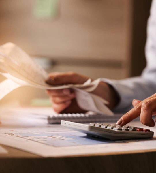 closeup-economist-using-calculator-while-going-through-bills-taxes-office